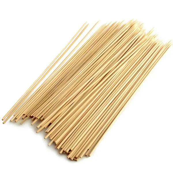 Large pile of natural bamboo skewers fanned out.