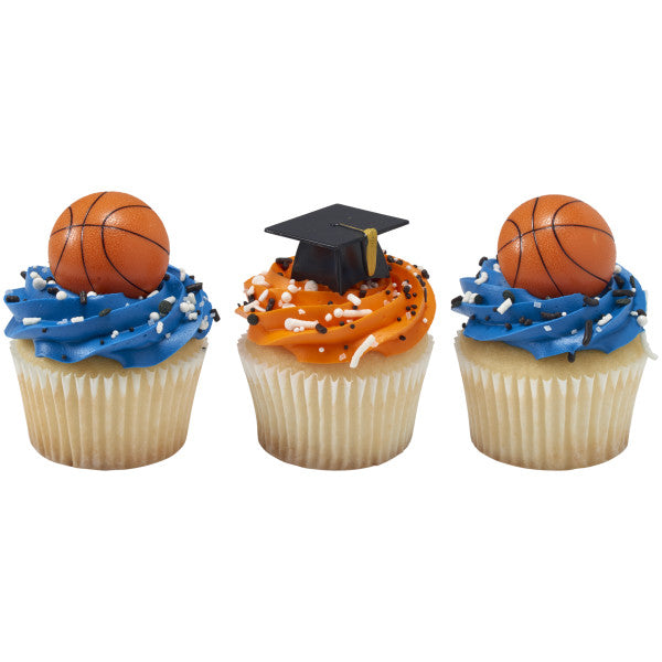 Trio of cupcakes with orange and blue frosting, two topped with basketball rings and one with a black graduation cap ring.