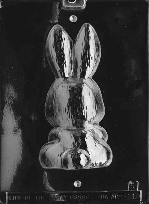 Clear plastic chocolate mold showing the back half of a bunny figure with long ears and rounded body, designed to pair with the front half to form a complete 3D bunny holding a basket.