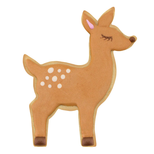 Cookie shaped like a standing deer, decorated in brown with white spots, pink ear detail, and black-tipped hooves.
