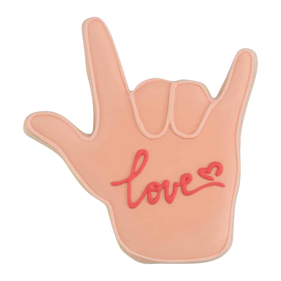 Decorated cookie shaped like a hand making the ASL 'I love you' gesture, with soft pink icing and the word 'love' piped in red.
