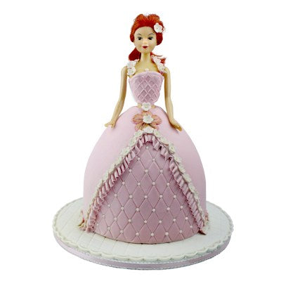 Decorated doll cake featuring a pink fondant dress with frill and quilted detailing, made using a PME doll cake pan.