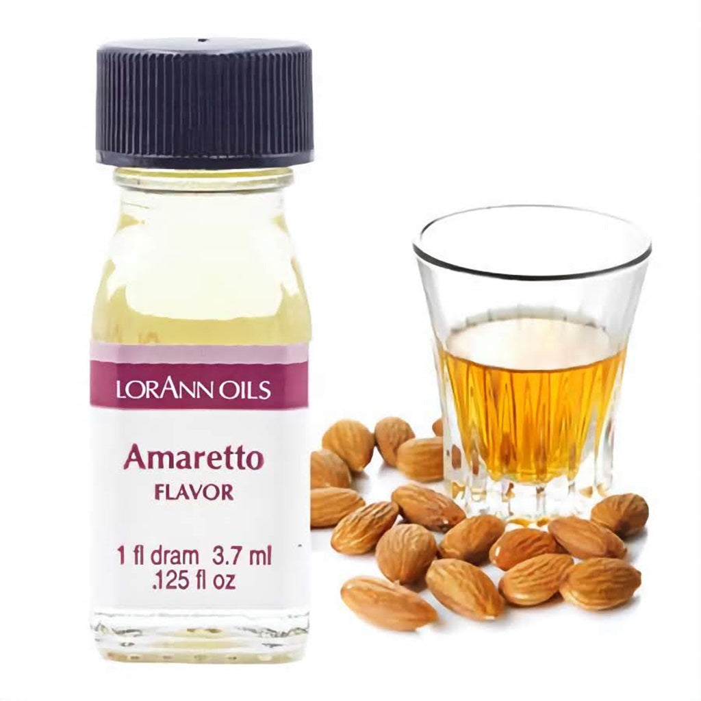 Small bottle of LorAnn Oils amaretto flavoring with almonds and a glass of amaretto beside it.