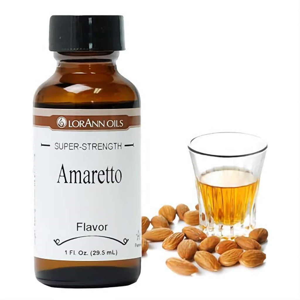 Bottle of LorAnn Oils super-strength amaretto flavoring with almonds and a glass of amaretto beside it.