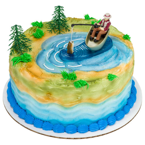 Round cake with blue and green landscape design and fishing cake topper featuring a jumping fish