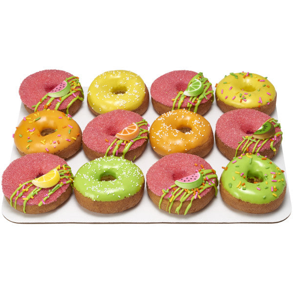 Assorted colorful donuts decorated with sprinkles and fruit slice pressed sugar toppers.