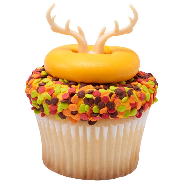 Cupcake decorated with orange frosting, antler topper, and covered in red, green, orange, and brown Thanksgiving sequins.
