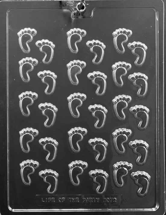 Clear mold sheet with multiple tiny footprint cavities; shallow depth and crisp toe detail; white background.