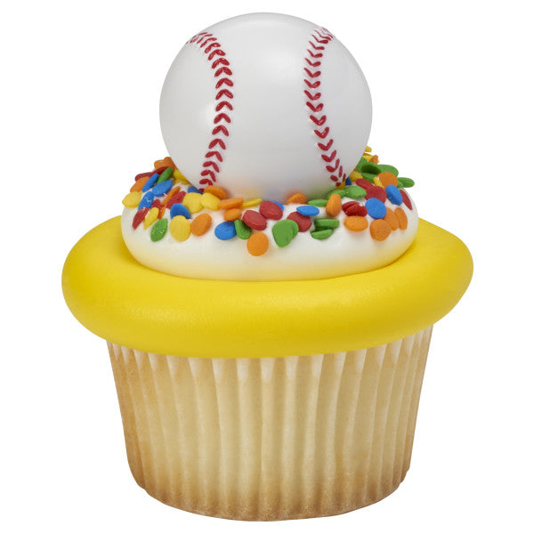Cupcake with white frosting, rainbow sprinkles, and a baseball ring topper.