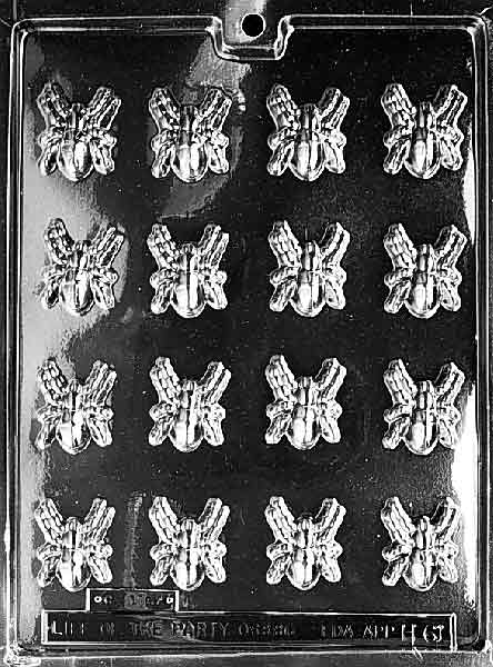 Clear multi-cavity mold with small, detailed spider shapes arranged in rows; each spider shows legs and body segments on a glossy plastic sheet.