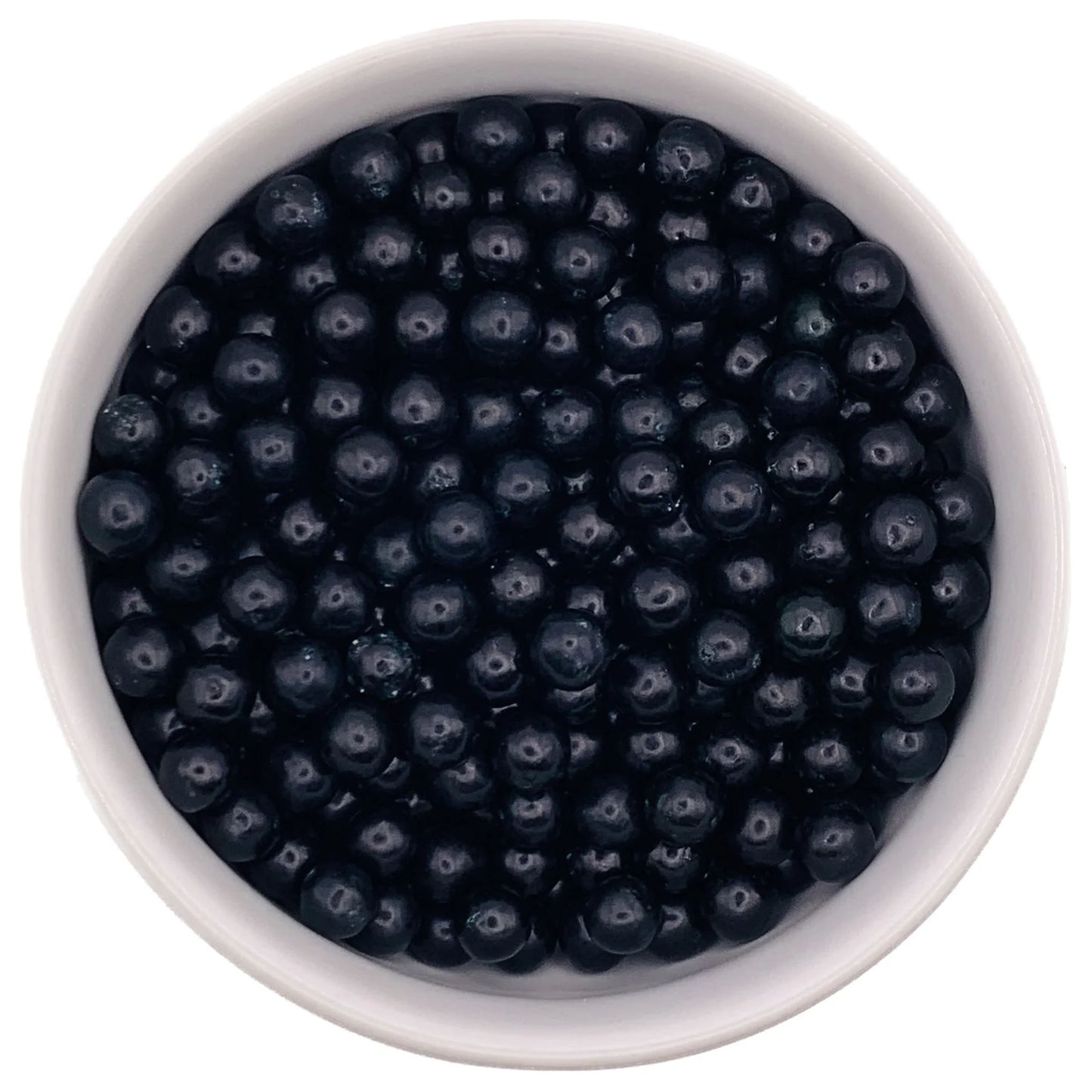 Top-down view of a white bowl filled with 7mm glossy black sugar pearls, used for decorating cakes and desserts.