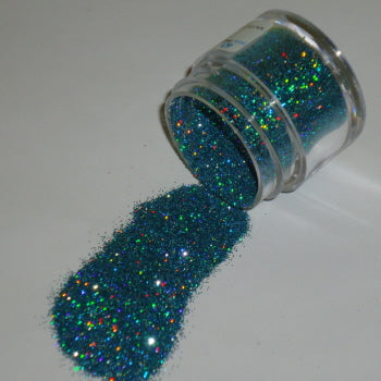 Iridescent blue topaz Galaxy Glitter Dust poured from a jar, sparkling with multicolored holographic reflections under the light.