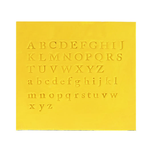 Yellow fondant mat with uppercase and lowercase serif-style alphabet impressions from PME Fun Fonts Collection 2.