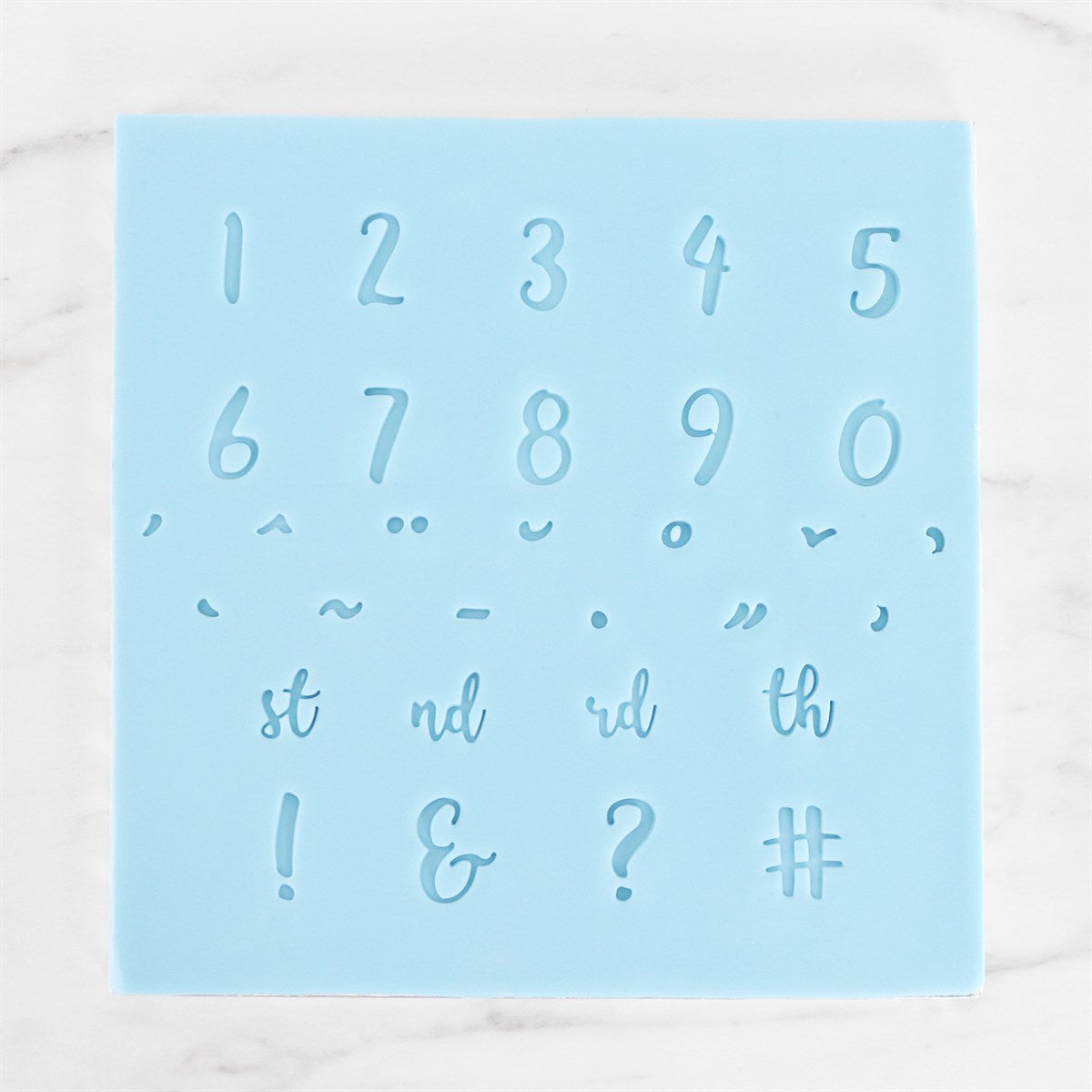 Close-up of number and punctuation impressions made using PME Fun Fonts stamp set on blue template.