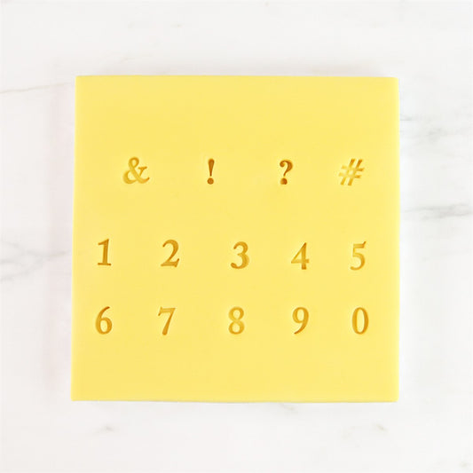 Close-up of yellow stamp sheet with numerals and punctuation from PME Fun Fonts Collection 2.