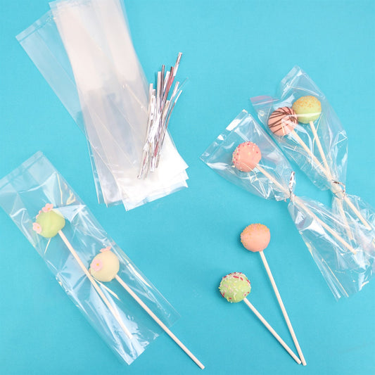 Clear PME cake pop bags with silver ties shown holding decorated cake pops on a blue background.