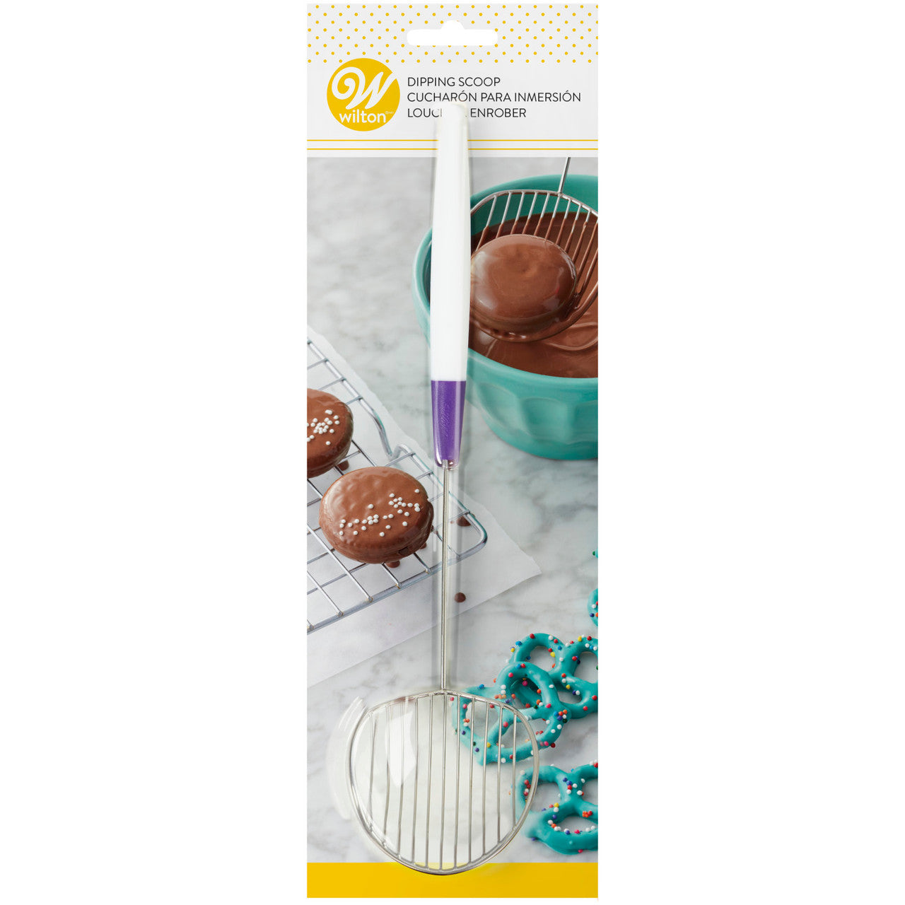 Wilton Candy Melt Dipping Scoop in retail packaging with dipped cookies and blue candy-coated pretzels on a marble surface.