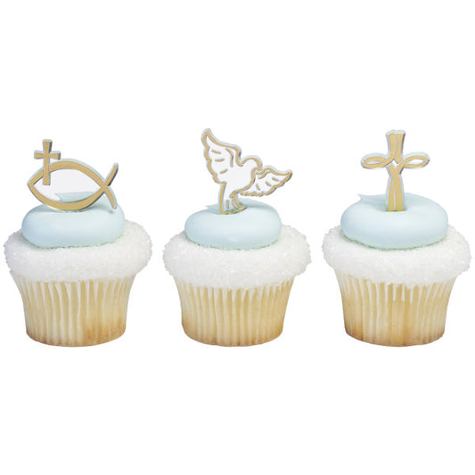 White and light blue cupcakes topped with gold and white religious picks in cross, dove, and fish shapes.