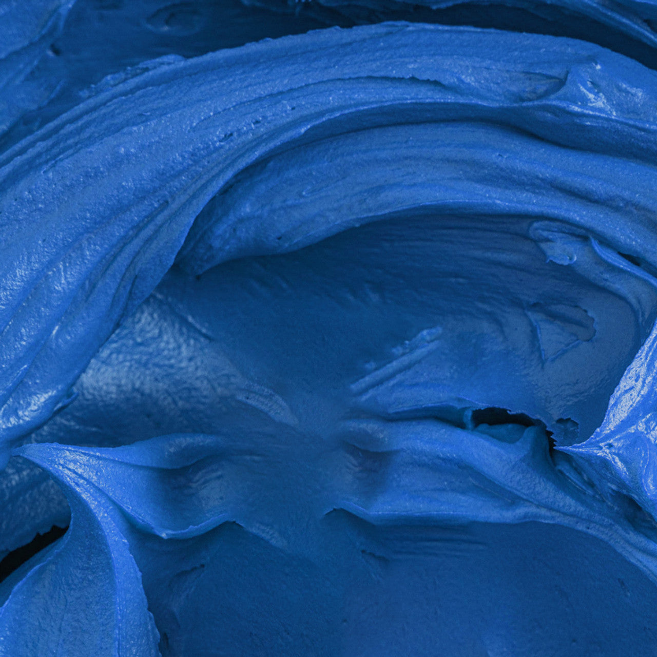 Close-up of vibrant cobalt blue buttercream colored with Colour Mill Cobalt Oil Blend, showing smooth whipped texture