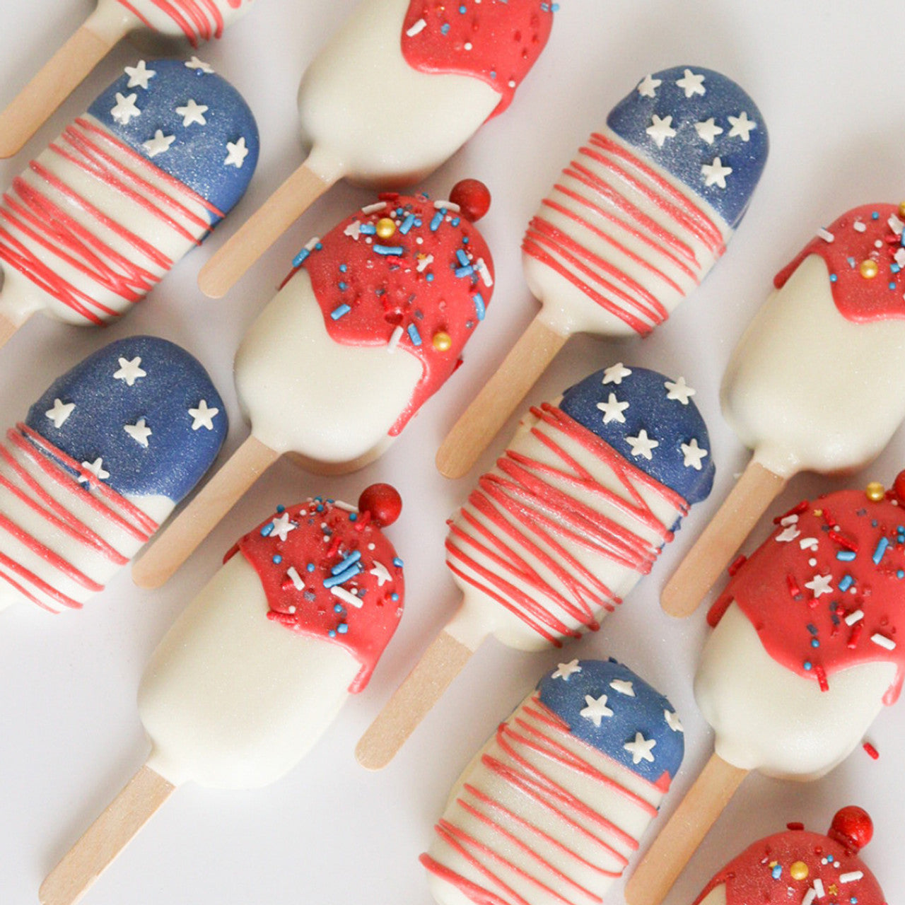Red, white, and blue chocolate-dipped treats featuring Colour Mill Navy used for patriotic cake pop designs
