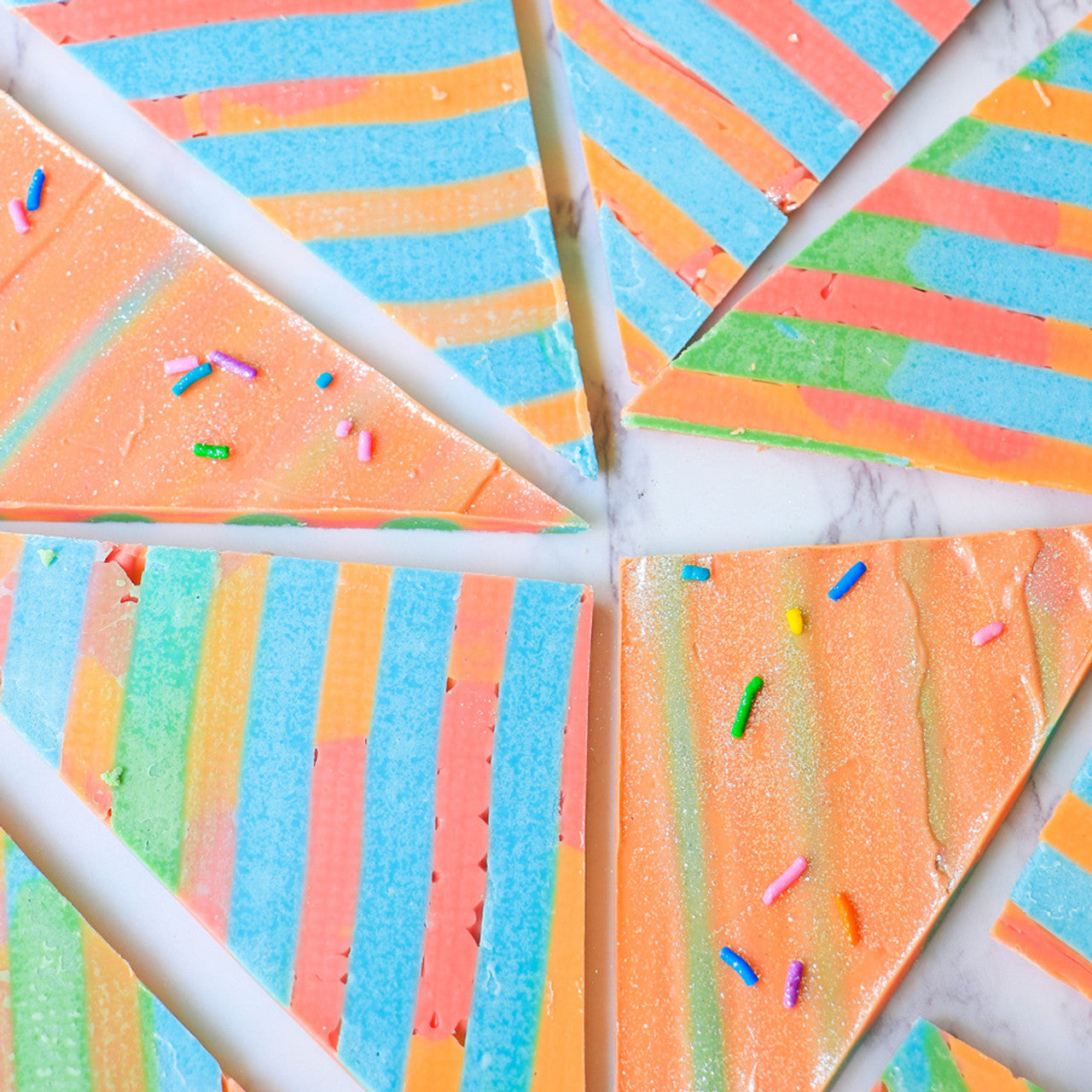 Colorful triangle chocolate bark featuring Sky Blue stripes and rainbow sprinkles