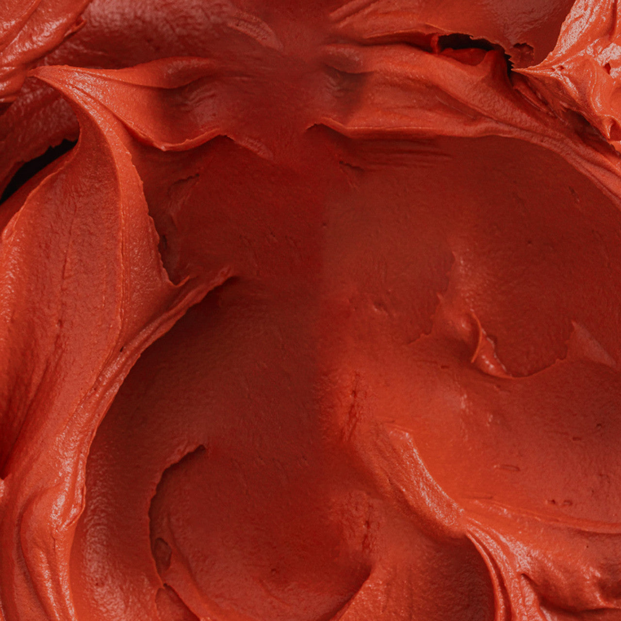 Richly blended buttercream tinted with Colour Mill Sunset oil-based coloring in a deep red-orange tone