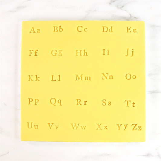Stamped letter impressions from PME Fun Fonts Collection 2 on yellow fondant for decorating cakes and cookies.