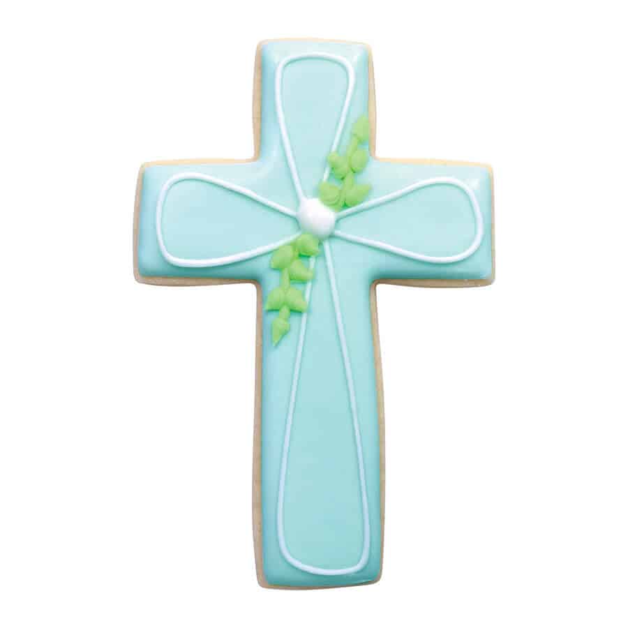 Blue cross-shaped cookie with white piping and green leaf detail, suitable for communions, Easter, and other faith-based events.