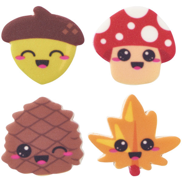 Four smiling edible pressed sugar decorations shaped like an acorn, mushroom, pine cone, and leaf, designed for fall-themed desserts.