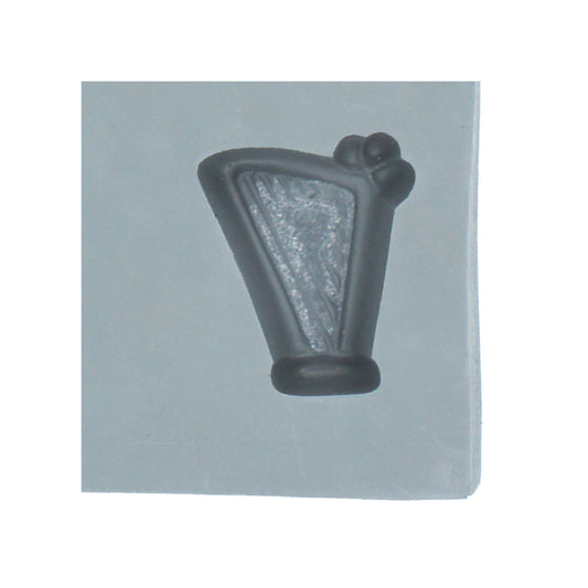 Close-up of harp rubber mint mold cavity featuring string detail and curved frame for music-themed or elegant candy making