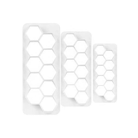 Ateco 3-piece hexagon fondant cutter set, featuring three white plastic cutters with multiple hexagonal cutouts for uniform designs.