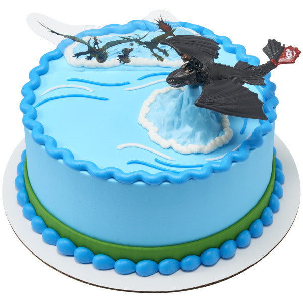 Round blue cake decorated with Toothless dragon topper and flying dragon pick for a How to Train Your Dragon birthday.