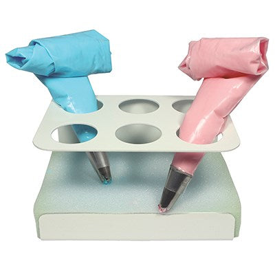 PME icing bag stand with six slots and a damp foam base, holding blue and pink piping bags upright for neat and efficient decorating.