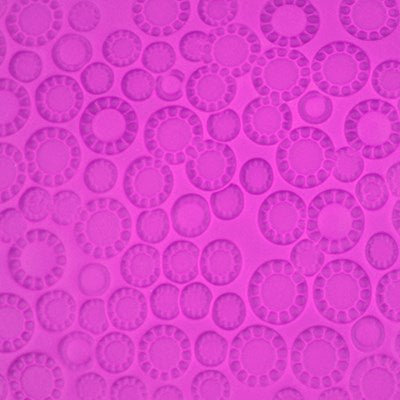 Close-up of embossed polka dot pattern on pink fondant using PME Polka Dot Impression Mat.