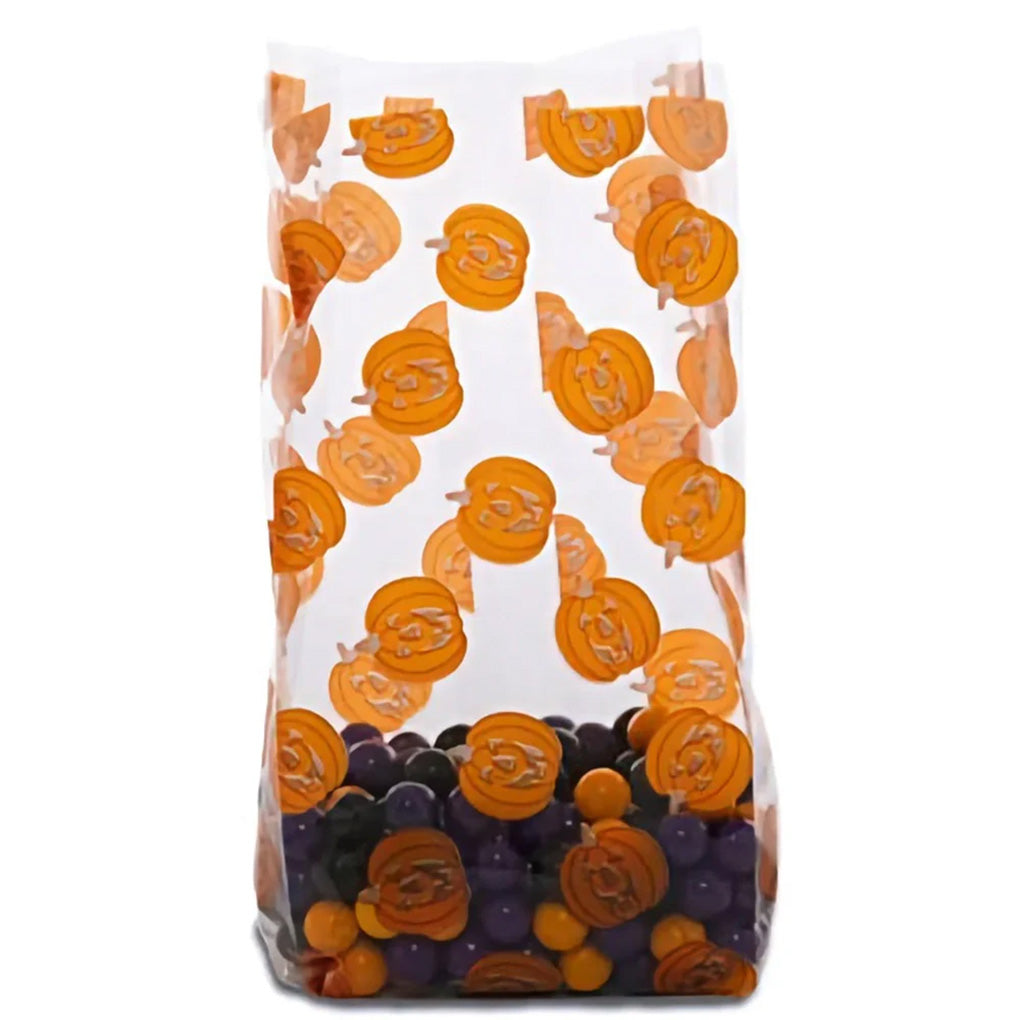 Clear medium cello treat bag printed with orange jack-o-lantern pumpkins, shown standing upright with purple and orange candies inside and a gusseted bottom.