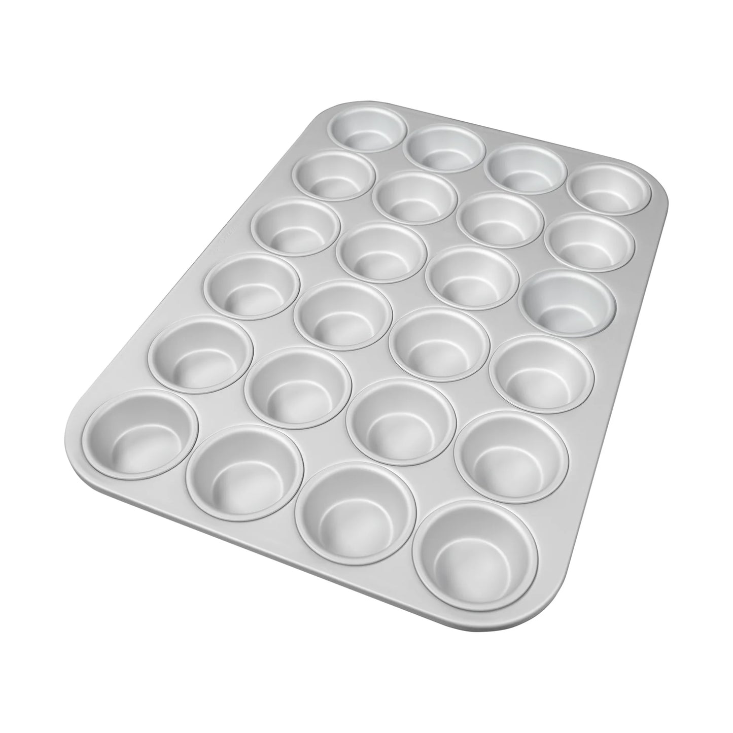 Silver mini muffin pan with 24 round cavities in a grid layout and a smooth rolled rim, shown at an angle on a white background.