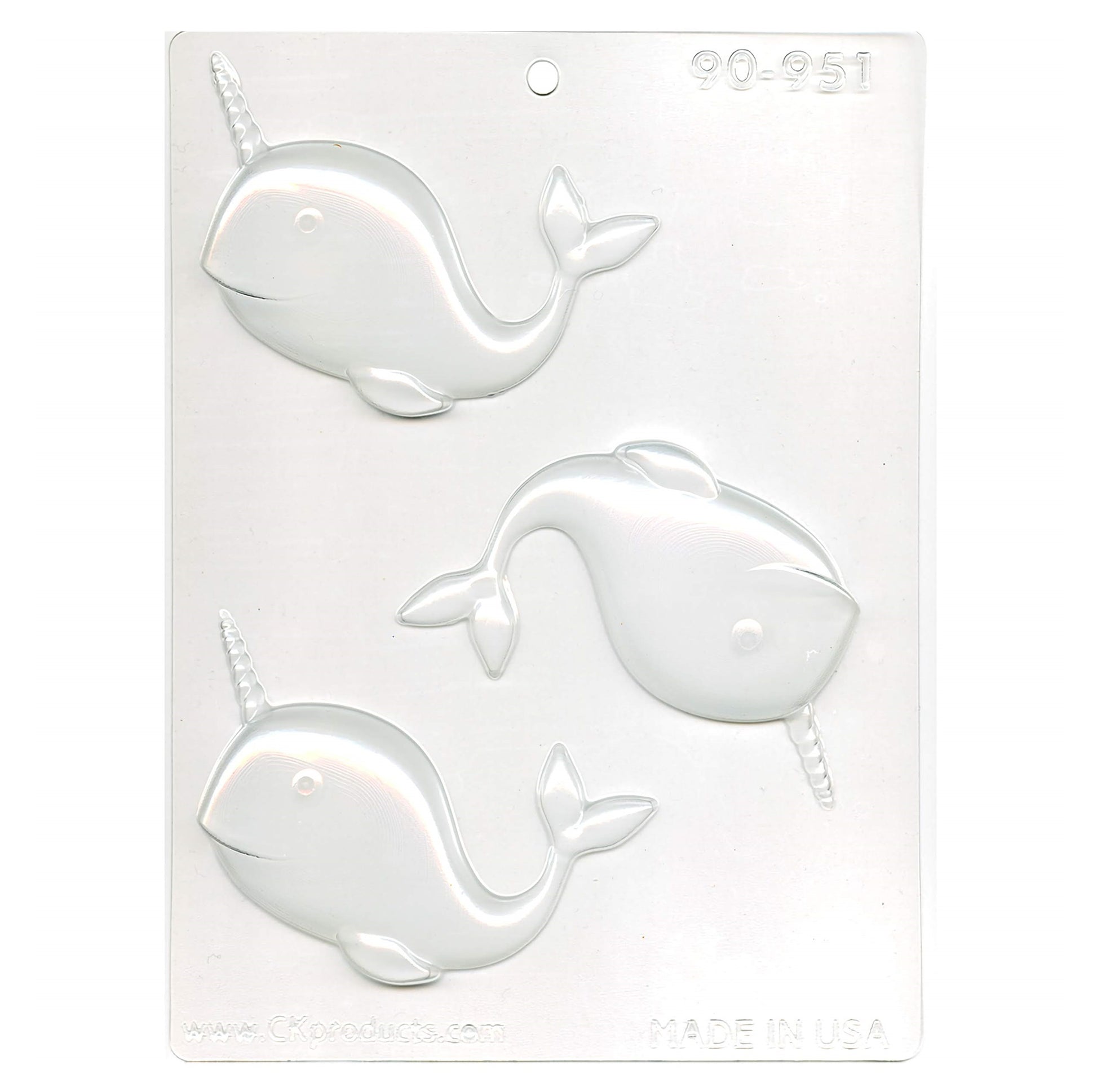 A clear plastic chocolate mold for creating narwhal-shaped treats, with three cavities each featuring the whimsical sea creature complete with a prominent tusk.