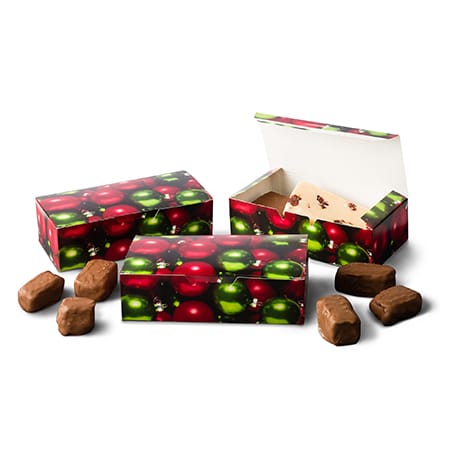 Chocolate truffles in decorative boxes with a fruit pattern on a white background