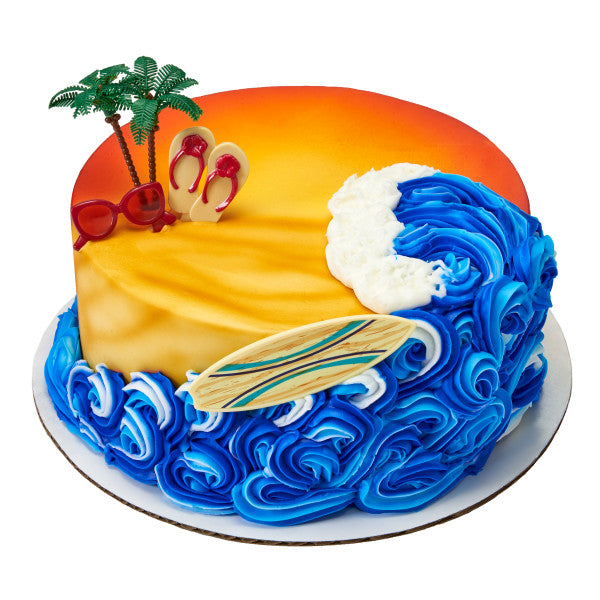 Cupcake topped with white and blue fondant, green grass icing, and plastic palm tree topper for a tropical island effect