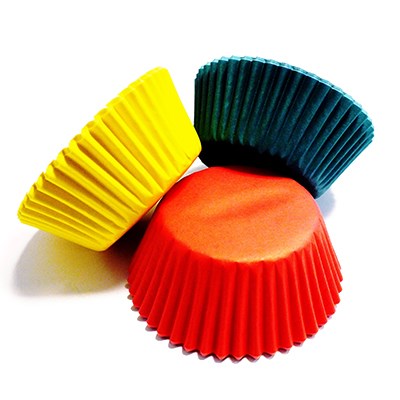 Three individual baking cups in red, yellow, and dark teal angled on white background.