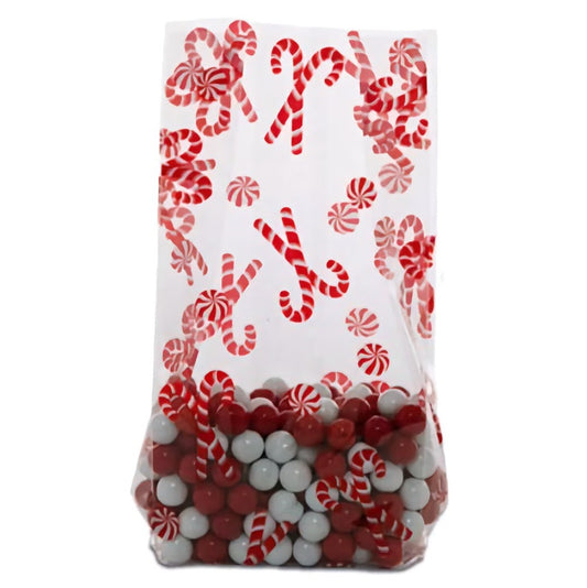 A large cellophane treat bag adorned with a vibrant peppermint candy and candy cane design against a transparent background. The bottom of the bag is filled with an assortment of red and white candies, echoing the peppermint theme. The festive pattern and the visible candies create a cheerful holiday presentation, perfect for seasonal gifts or party favors.