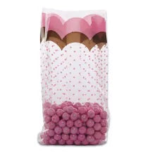 Clear gusseted cello bag with pink polka dots and pink and gold scalloped top border, filled with pink candy, ideal for party favors or elegant treat packaging.