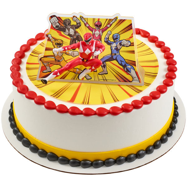 Round cake decorated with red and black icing beads and topped with Power Rangers Morphin Time Red Ranger figurine and explosion backdrop.