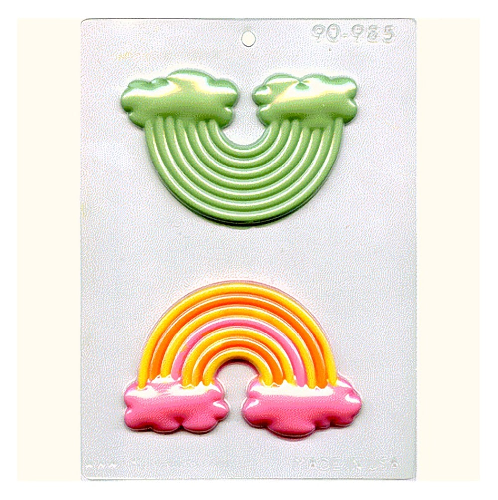 A Chocolate mold featuring 2 rainbow shaped cavities. These cavities are filled with colored chocolate to demonstrate how the mold can be used.