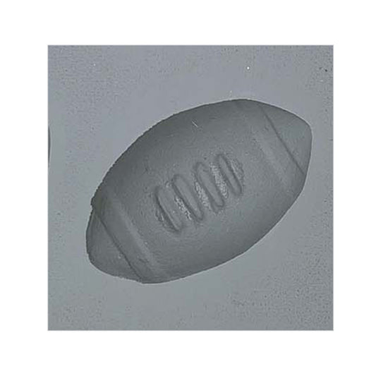 Close-up of a football-shaped cavity in a natural rubber mint mold, perfect for making themed cream cheese mints, chocolates, or fondant decorations.