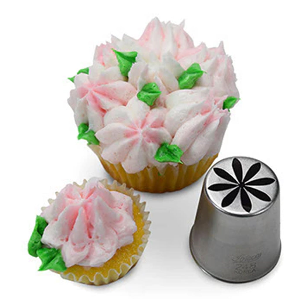 Metal Russian piping tip with an eight-petal flower cutout shown beside cupcakes topped with pale pink buttercream flowers and small green leaves on a white background.