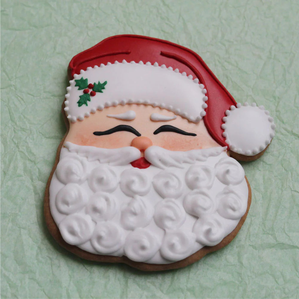 Santa cookie with a detailed white beard, red hat, and holly decorations, showcasing festive icing designs.