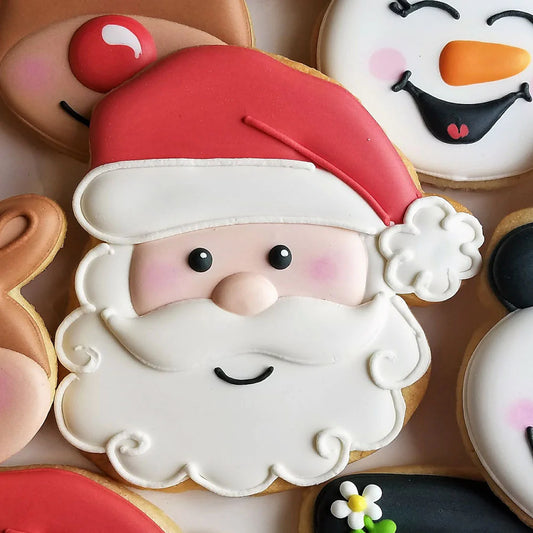 Santa-shaped cookie decorated with red hat, white beard, and cheerful face, made with the Santa face cookie cutter.