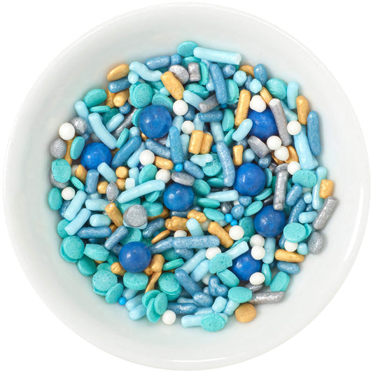 A bowl filled with Seaside Deluxe Sprinkle Blend showcasing a marine-inspired mix of various blue and gold sprinkles, including shiny beads, rods, and sugar rocks, perfect for ocean-themed desserts.