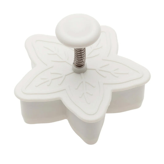 White 2-inch snowflake plunger cutter with a round button and visible spring mechanism on top, shown on a white background.